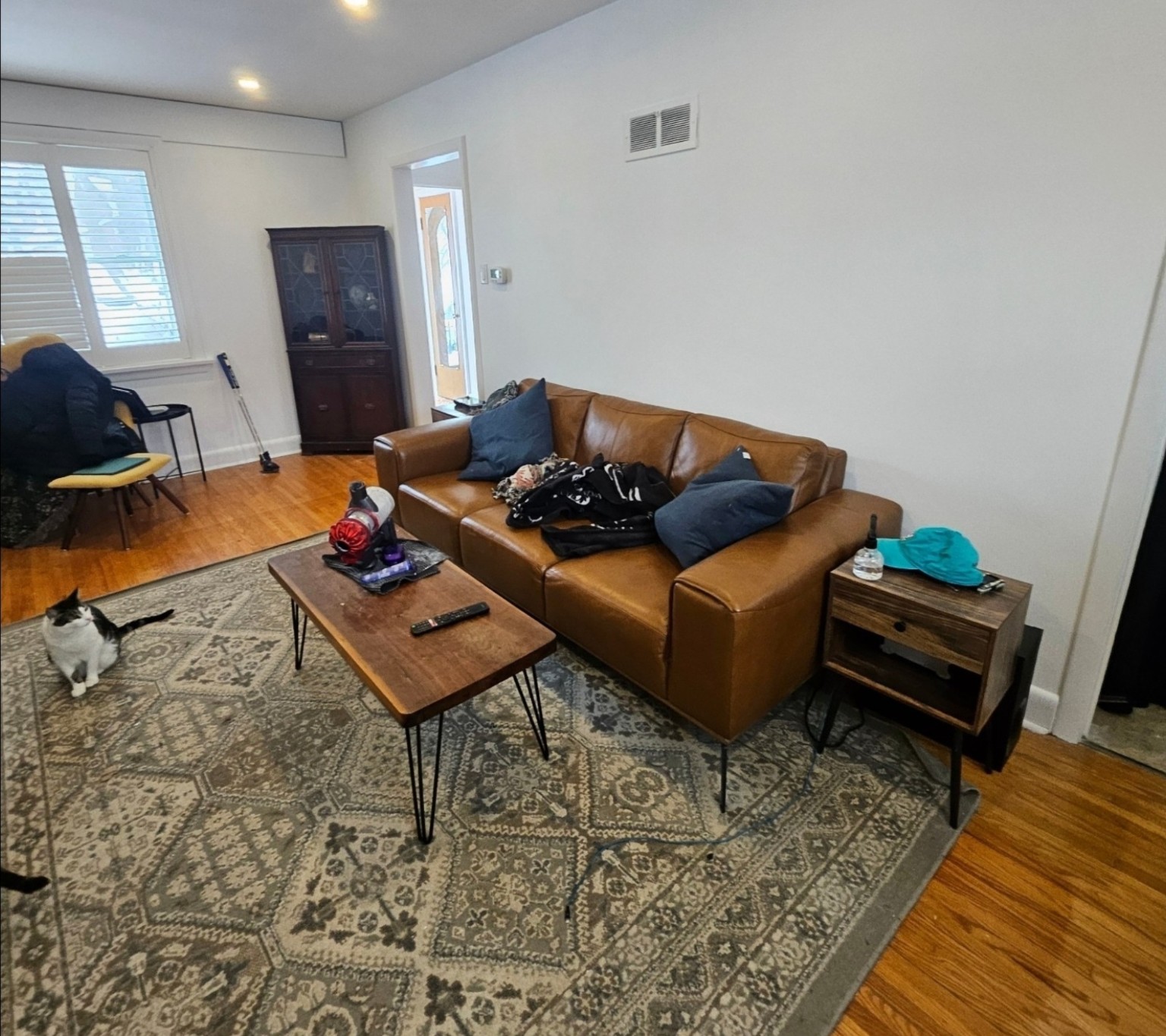 Before: living room with brown leather sofa before staging