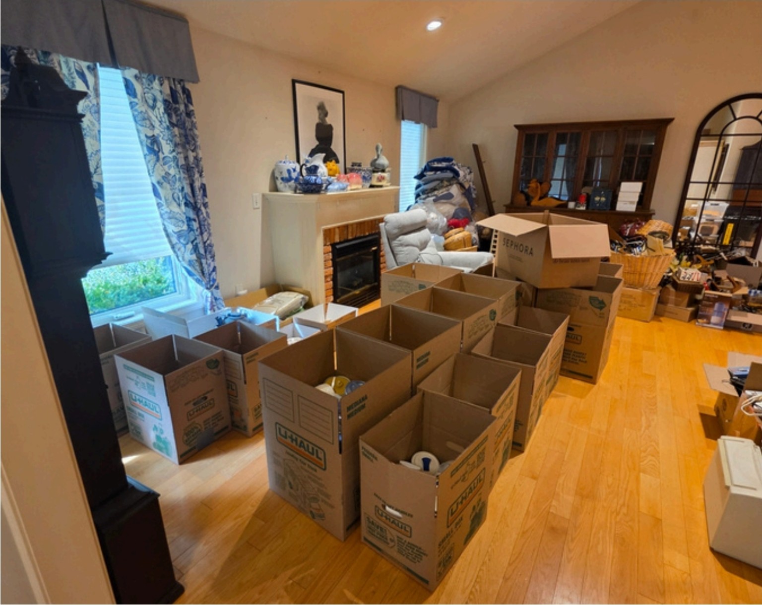 Before: living room filled with moving boxes and household items