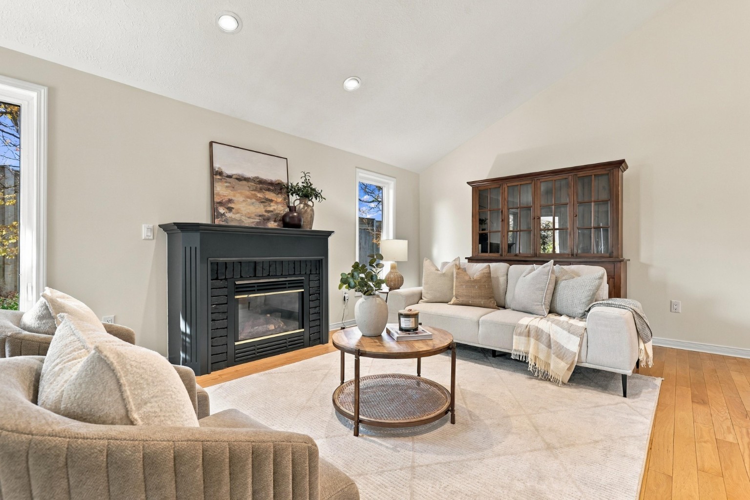 After: living room staged with light furnishings around the fireplace
