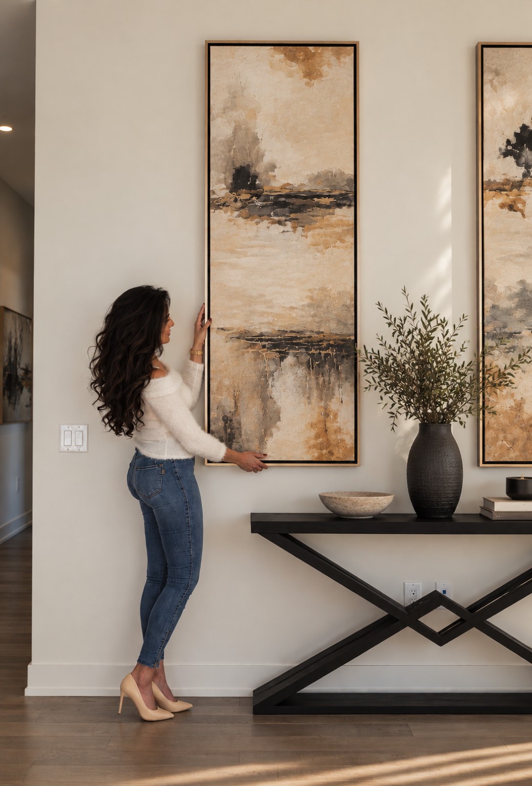 Eleganterior founder arranging artwork in a styled interior