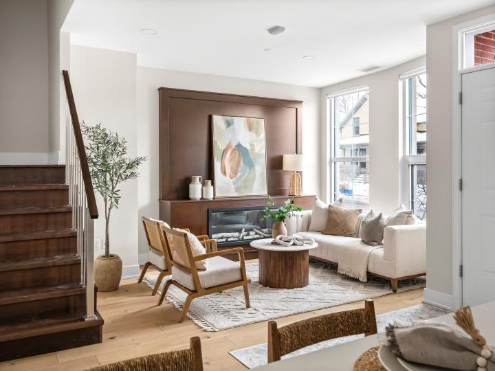 Staged living room with oak floors, fireplace and neutral seating